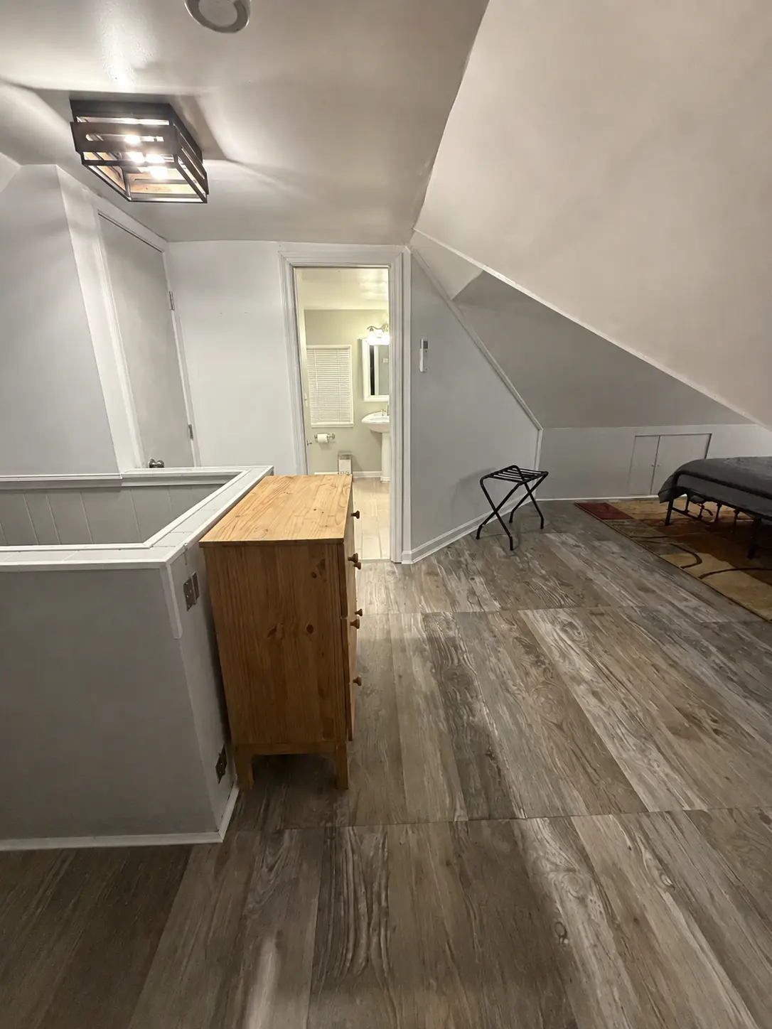Upstairs landing with wood-look flooring, a pine dresser and a doorway to the bathroom